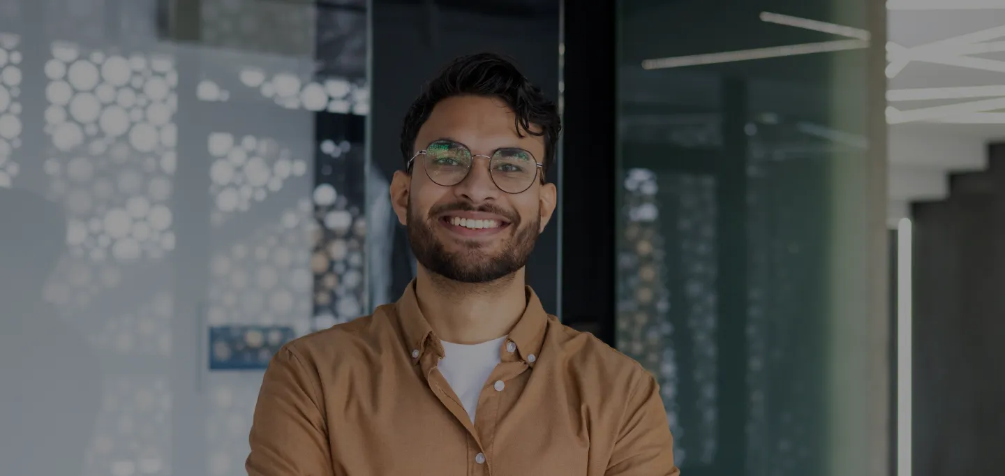Young man with glasses smiling in a modern dental office
